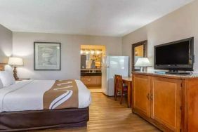 Spacious delux king room with TV, business desk, and fridge at Quality Inn Pasadena.