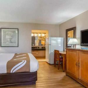 Spacious delux king room with TV, business desk, and fridge at Quality Inn Pasadena.