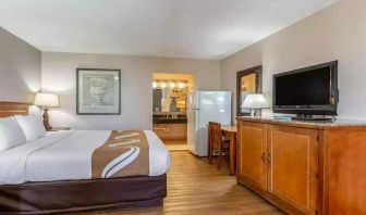 Spacious delux king room with TV, business desk, and fridge at Quality Inn Pasadena.