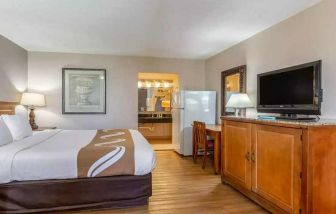Spacious delux king room with TV, business desk, and fridge at Quality Inn Pasadena.