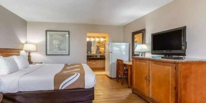 Spacious delux king room with TV, business desk, and fridge at Quality Inn Pasadena.