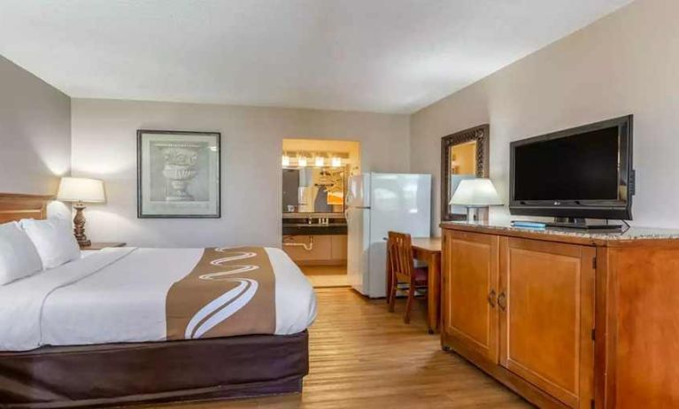 Spacious delux king room with TV, business desk, and fridge at Quality Inn Pasadena.