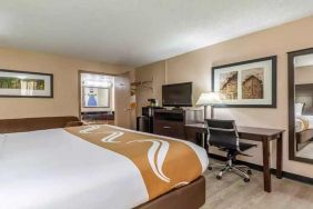 King bedroom with business desk and TV at Quality Inn Pasadena.