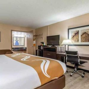 King bedroom with business desk and TV at Quality Inn Pasadena.