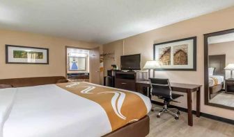 King bedroom with business desk and TV at Quality Inn Pasadena.