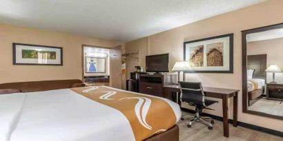 King bedroom with business desk and TV at Quality Inn Pasadena.