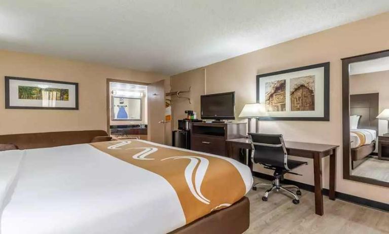 King bedroom with business desk and TV at Quality Inn Pasadena.