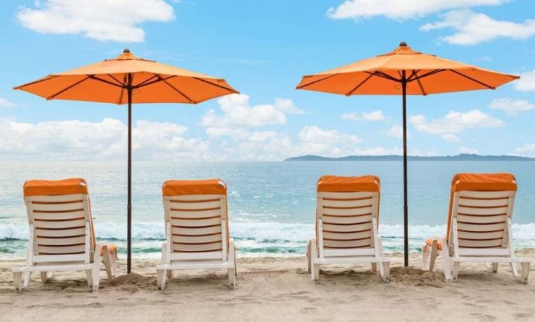 Enjoy a beach chair and beach umbrella on the beach at Pacific Edge Hotel.