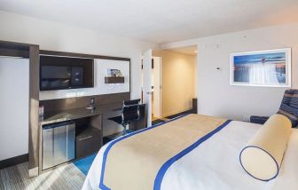 Comfortable king suite with work desk, mini-fridge, and TV at Southbank Hotel Jacksonville Riverwalk.