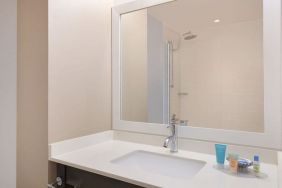 Spacious guest bathroom with shower at Courtyard By Marriott New York JFK Airport.