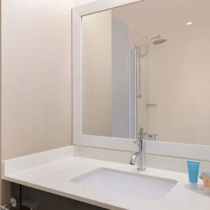 Spacious guest bathroom with shower at Courtyard By Marriott New York JFK Airport.