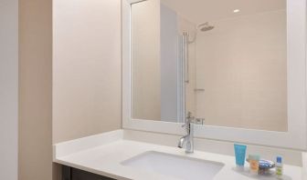 Spacious guest bathroom with shower at Courtyard By Marriott New York JFK Airport.