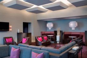 Comfortable couches in open-plan setting ideal for coworking at Courtyard By Marriott New York JFK Airport.