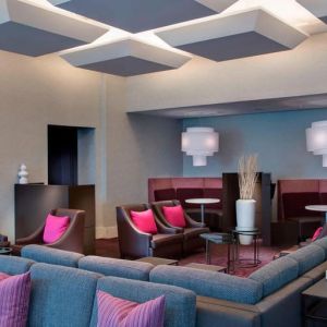 Comfortable couches in open-plan setting ideal for coworking at Courtyard By Marriott New York JFK Airport.