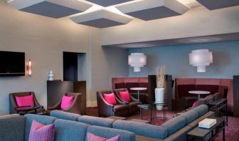 Comfortable couches in open-plan setting ideal for coworking at Courtyard By Marriott New York JFK Airport.