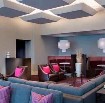 Comfortable couches in open-plan setting ideal for coworking at Courtyard By Marriott New York JFK Airport.