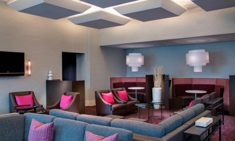 Comfortable couches in open-plan setting ideal for coworking at Courtyard By Marriott New York JFK Airport.