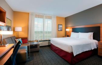 Spacious king suite with work desk and couch at TownePlace Suites Orlando at FLAMINGO CROSSINGS.