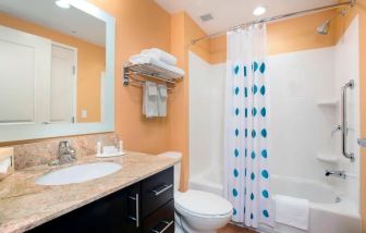 Spacious guest bathroom with shower and bath at TownePlace Suites Orlando at FLAMINGO CROSSINGS.