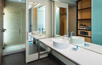 Spacious guest bathroom with shower at Aloft Miami Aventura.