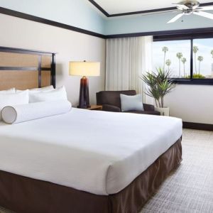 Comfortable king bedroom with couch and work station at The Ambrose Hotel Santa Monica.