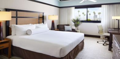 Comfortable king bedroom with couch and work station at The Ambrose Hotel Santa Monica.