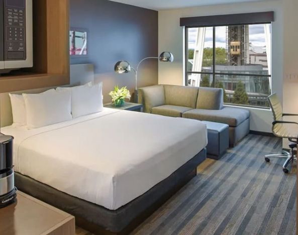 Comfortable king suite with business desk, TV, coffee machine, and lounge at Hyatt House Seattle Downtown.