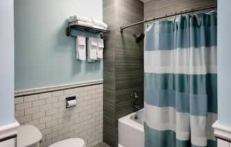 Private guest bathroom with shower and bath at Hotel Bijou.