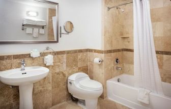 Private guest bathroom with shower and bath at Porto Vista Hotel.