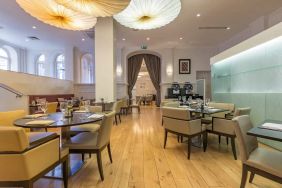 Tables and chairs in the airy, well-lit hotel restaurant.