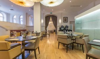 Tables and chairs in the airy, well-lit hotel restaurant.