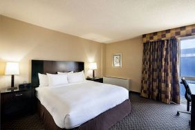 The Radisson Hotel JFK Airport’s king room, with large bed and window.