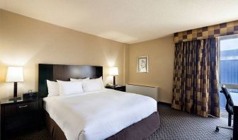 The Radisson Hotel JFK Airport’s king room, with large bed and window.