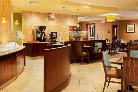 On-site dining at the Radisson Hotel JFK Airport, with hard floors and small tables.