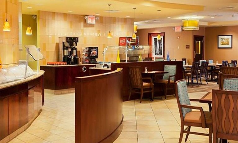 On-site dining at the Radisson Hotel JFK Airport, with hard floors and small tables.