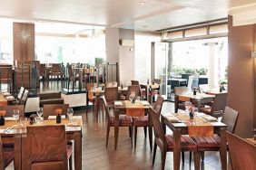 Indoor seating with tables for two or four diners, with large windows and a window floor.