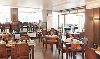 Indoor seating with tables for two or four diners, with large windows and a window floor.