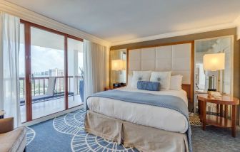 Spacious king room with balcony and natural light at Naples Grande Beach Resort.