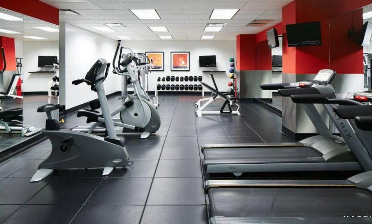 The hotel’s fitness center is equipped with multiple exercise machines, benches, and weights.