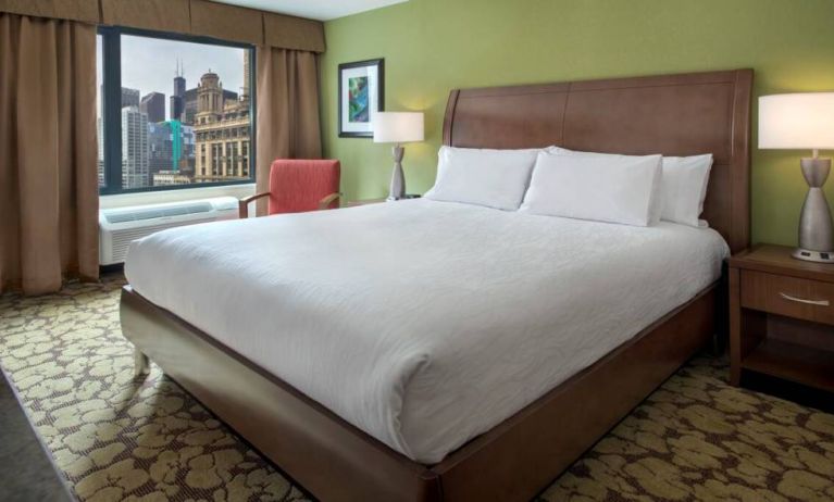 Double bed guest room within the Hilton Garden Inn Chicago Downtown Riverwalk, with city views through the large window.