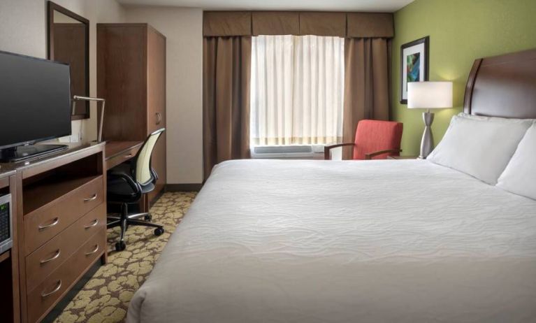 Guest room in the Hilton Garden Inn Chicago Downtown Riverwalk, including large bed, window, and desk and chair for working.