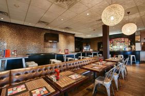 On-site dining at the Best Western Plus Newark Airport’s restaurant, which has small tables and a hard floor.