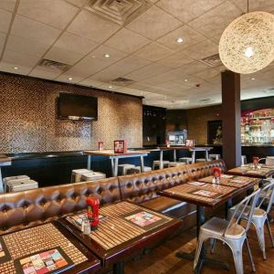 On-site dining at the Best Western Plus Newark Airport’s restaurant, which has small tables and a hard floor.