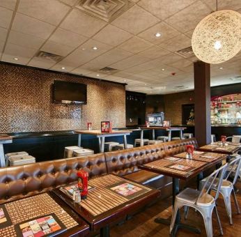 On-site dining at the Best Western Plus Newark Airport’s restaurant, which has small tables and a hard floor.