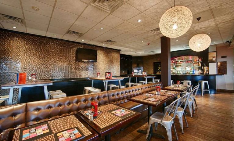 On-site dining at the Best Western Plus Newark Airport’s restaurant, which has small tables and a hard floor.