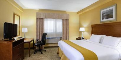 Double bed guest room in Holiday Inn Express Philadelphia Airport, with window and TV set.