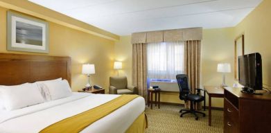 Guest room in Holiday Inn Express Philadelphia Airport, with double bed and chair/desk for working.