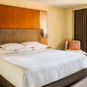 Double bed guest room in Hyatt Regency Chicago, with large window offering views of the urban vista.