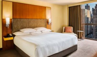 Double bed guest room in Hyatt Regency Chicago, with large window offering views of the urban vista.