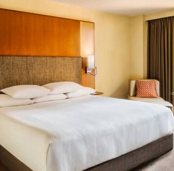 Double bed guest room in Hyatt Regency Chicago, with large window offering views of the urban vista.